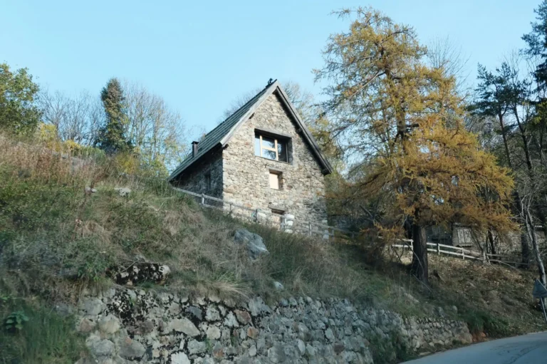 Grange construite en pierre, perpendiculaire à la pente.