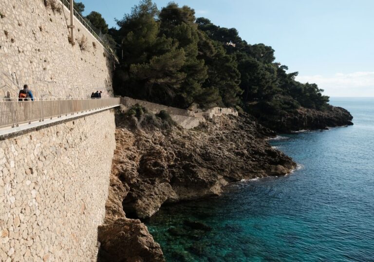 Sentier du littoral accroché au mur de soutènement de la voie ferrée.